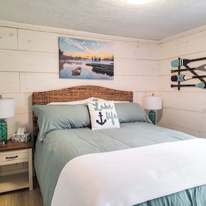 Comfortable queen bed with bedside table with touch lamps with charging plugs.