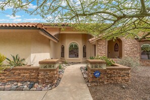 This charming house has a beautiful stone wall and inviting walkway.