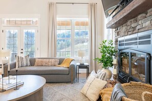 Relax in the inviting living space featuring high ceilings and rustic charm, perfect for family gatherings. - The Regal - Sevierville, TN