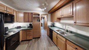 Fully stocked kitchen with stove, microwave, dishwasher and full size refrigerator with freezer.  Plenty of pots and skillets, even a crockpot for that chili!