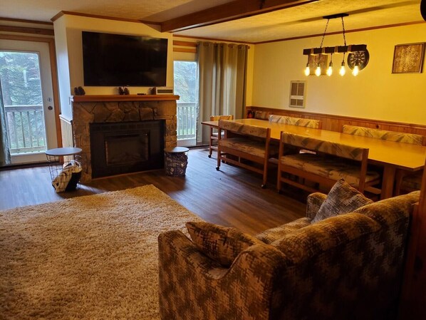 Open living and dining room with electric fireplace.  The impressively sized table seats at least 12! 