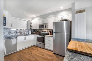 View of the kitchen, including dishwasher, stove, oven & fridge.