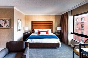 An elegant room featuring a plush king bed, complete with a cozy seating area and warm, inviting decor.
