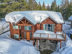 Cabin exterior during ski season with forest and mountain views all around!