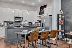 2nd Floor: Fully equipped chefs kitchen featuring high-end stainless-steel appliances, and culinary essentials while boasting a kitchen island for meal prepping.