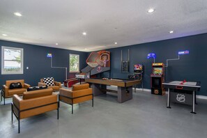 Game room packed with various games - air hockey, pool table, basketball, arcade games, Smart TV