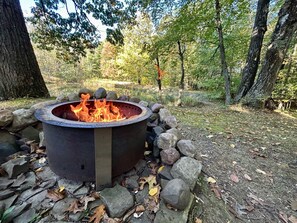 Breoo Smokeless Firepit overlooking pond.  Six Adirondack chairs for relaxing.