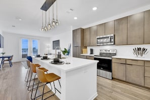 Whip up your favorite meals in a sleek kitchen equipped with state-of-the-art appliances, featuring a contemporary and inviting design.