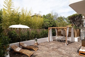 Relaxation area of your accommodation with outdoor dining area and sunbeds, perfect for unwinding at Mandara Beach.
