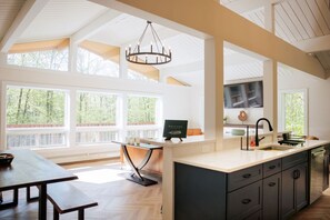 The open Great Room has a beautiful wall of windows looking out into the Vermont wilderness. Chevron flooring make the space look and feel unique.