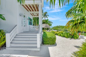 Private Entry Terrace | Waterfront terrace complete with rocking chairs + ceiling fan.