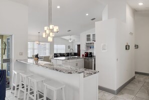 Fully equipped kitchen with breakfast bar capable of seating four guests