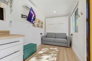 By day, the Murphy bed tucks away, creating a bright and open living area perfect for lounging or watching your favorite shows on the Smart TV