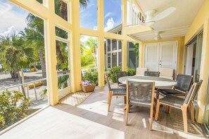 Screened patio with vaulted ceilings and a dining area. 