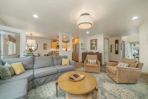 Living room with wrap around couch, gas fireplace, desk workspace.