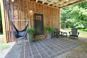 Front entry, covered patio area with seating and swing chair