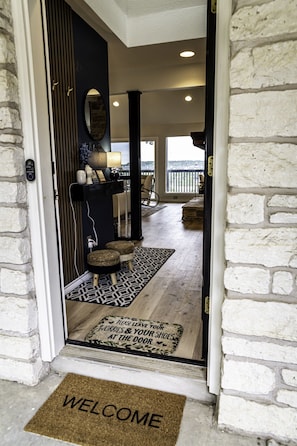As you step into the hallway of the lakehouse, you're greeted by an ambiance that seamlessly bridges the interior with the breathtaking natural beauty just beyond.