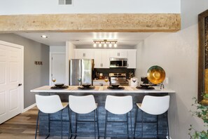 Dining area offers seating for four with chic bar stools adding a touch of flair