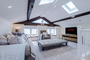 The first floor enjoys a large open-plan sitting room and bedroom with exposed beams