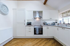 Well-equipped kitchen with an electric oven and induction hob, coffee machine and dishwasher