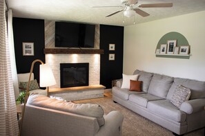 Living Room with comfy couches, fireplace and smart TV