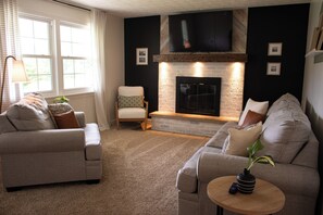 Living Room with comfy couches, fireplace and smart TV