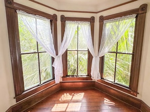 The palm trees by the window offers some privacy and a relaxing backdrop.