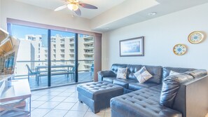 The spacious living groom with L shaped leather couch, and TV