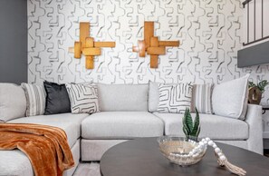 Warmth and charm meet in our cozy living room adorned with wood-crafted wall decor