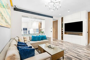 Living Room: Sleek design with vibrant cushions, a chic chandelier, and a view to inspire relaxation!