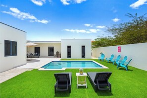 Soak up the sun by the private pool area of the home in Noord, Aruba - Unwind in the comfort of cozy beach chairs and pamper yourself with fresh towels provided. - Delight in the views of the lush surroundings and convenience of refreshing water