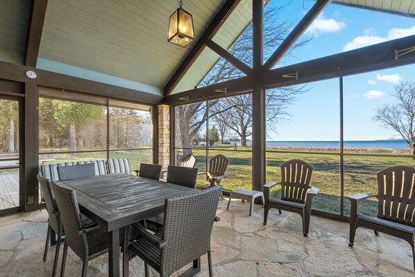 Screened/ glass patio includes multiple seating options and views