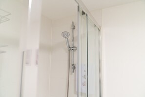 Bathroom with a walk-in shower. Complimentary toiletries are provided.