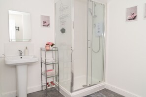Bathroom with a walk-in shower. Complimentary toiletries are provided.