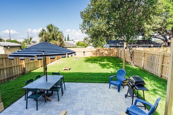 The lawn is expansive, offering plenty of space for various outdoor activities, like the provided cornhole, GIANT Genga & Connect four, and grill