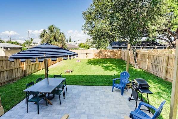 The lawn is expansive, offering plenty of space for various outdoor activities, like the provided cornhole, GIANT Genga & Connect four, and grill