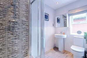 Large ensuite bathroom with a standup shower, sink and toilet