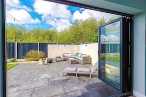 This is the view from the conservatory looking out onto the sun lounger and the seating area outdoors