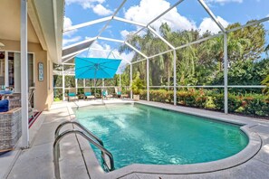 Screened patio area with heated pool, sun loungers, dining and lounging areas, a gas grill, outside TV and giant Connect 4 game. Perfect for Florida living in the sunshine!