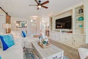 Spacious, light and bright living room with a relaxed, vacation vibe, beautiful wood style tiled floors and a 65" SmartTV.
