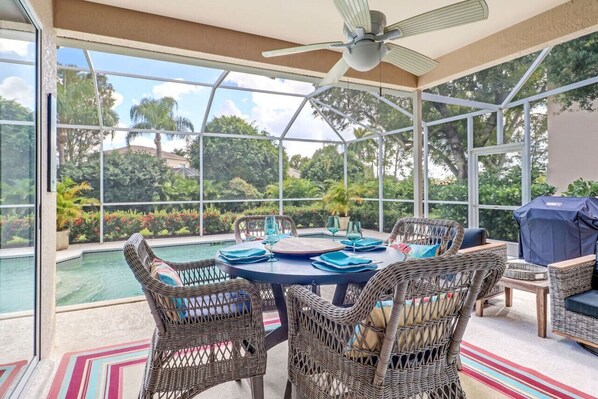 Screened patio area with heated pool, sun loungers, dining and lounging areas, a gas grill, outside TV and giant Connect 4 game. Perfect for Florida living in the sunshine!