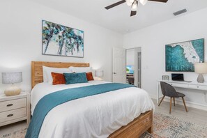 Primary bedroom with walk-in closet, private bathroom, queen size bed and smart TV. Desk area for those who need to get some work done.
