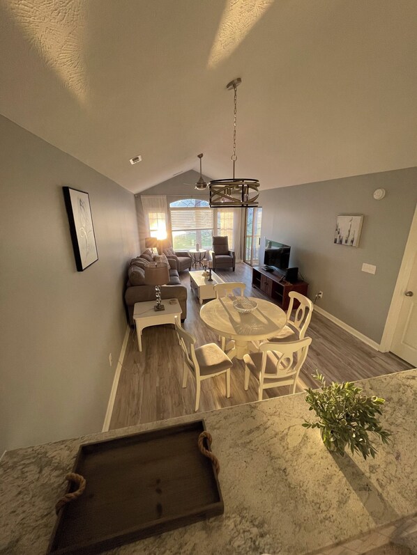 Living and dining area with access to patio with water view.