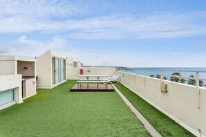 The rooftop is a shared space with sun loungers and a picnic bench with uninterrupted coastal views. 
