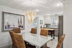 This elegant dining area sets the perfect stage for memorable meals and gatherings.  The spacious table comfortably seats six guests, inviting conversation and connection.  The beautiful chandelier adds a touch of sophistication and elegance to the ambiance.  This haven is perfect for hosting intimate dinners or enjoying family meals in style.