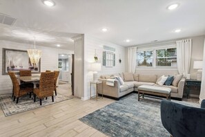 This stylish living room seamlessly blends modern design with functionality.  Enjoy your favorite shows and movies on the smart TV, creating a captivating entertainment experience.  Strategically placed lighting and ample natural light from beautiful windows create a bright and inviting atmosphere.  Relax on comfortable furniture and gather around the stylish center table for c...