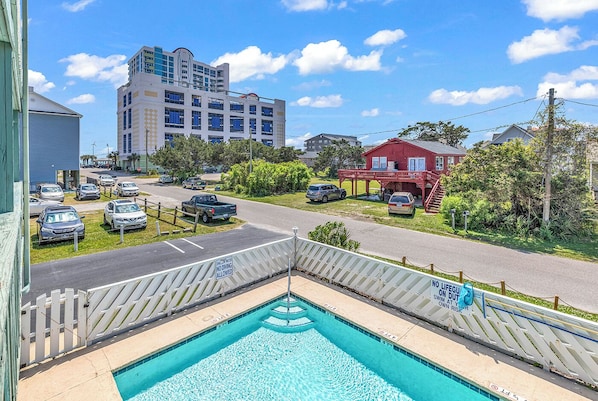 Balcony view: Overlooking the pool with a peak ocean view