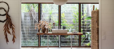 The boathouse bathroom opens into a private rainforest garden