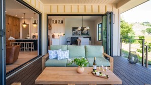 Lounge in the outdoor covered seating with a glass of local wine