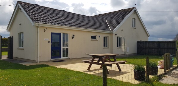 exterior photo of property with outdoor bench on the slabs, fenced around, planters